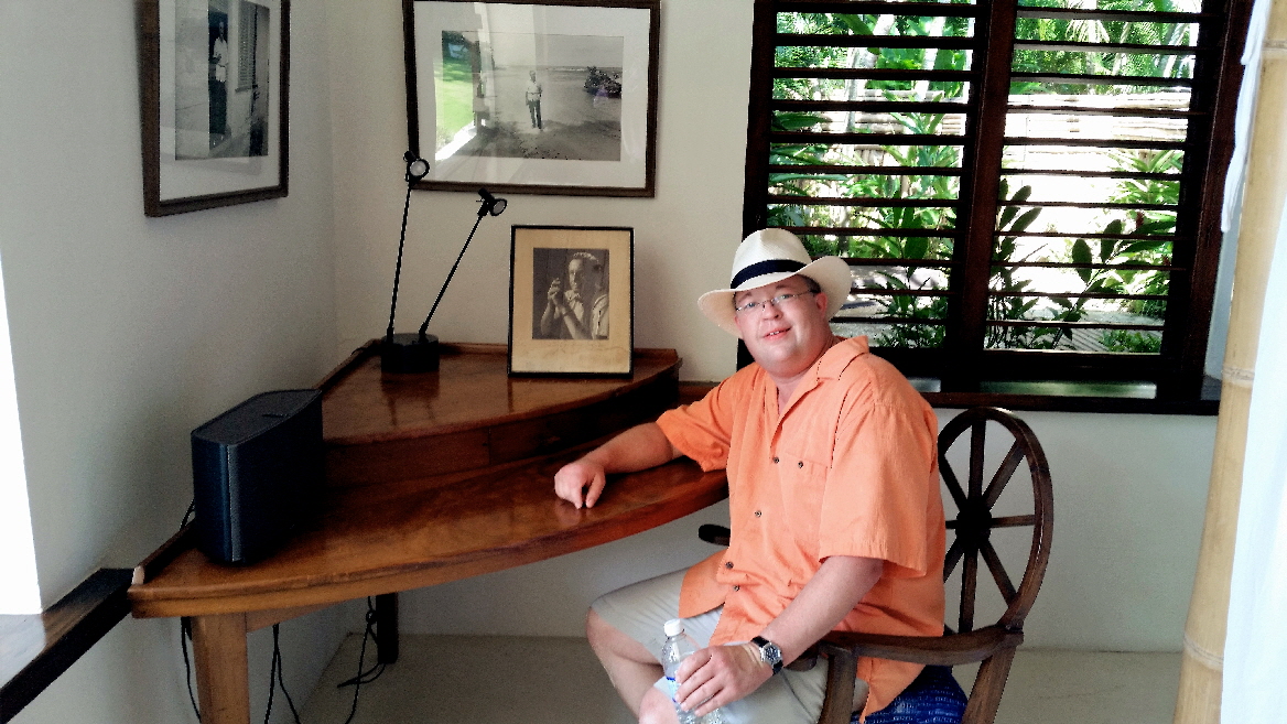 Travis sitting at Ian Fleming's desk in Jamaica